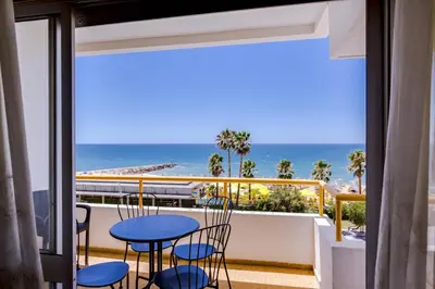a balcony with a table and chairs and a view of the ocean at York - Sea view - Quarteira in Quarteira