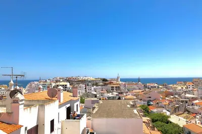 a view of a city with the ocean in the background at OLDTOWN great Terrasse & ROOFTOP in Albufeira