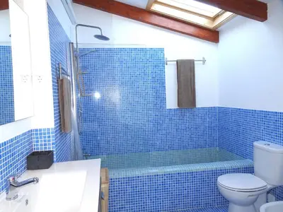 a blue tiled bathroom with a tub and a toilet at Gold by Check-in Portugal in Albufeira
