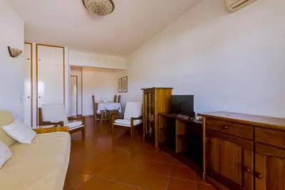 a living room with a couch and a tv in a room at Village Atlântico Apartment in Vilamoura
