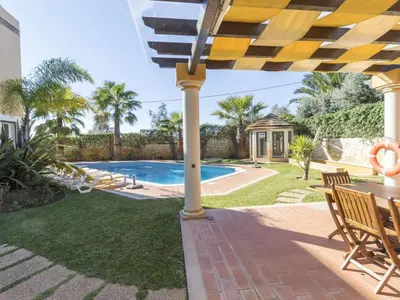 a patio with a table and chairs and a swimming pool at Casa Campo Spacious Living Private Pool Tranquil Setting in Guia