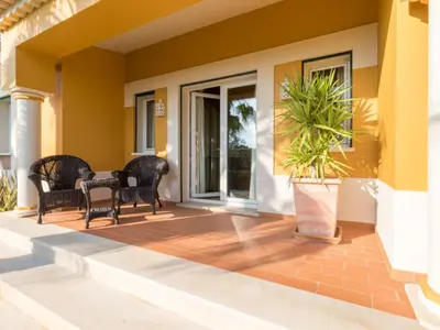 a porch with black chairs and a potted plant at Casa Campo Spacious Living Private Pool Tranquil Setting in Guia