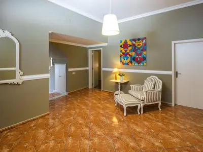 a living room with chairs and a table and a painting at Beautiful Loule Villa Villa Quinta Tropical Private Pool Air Conditioning in Loulé