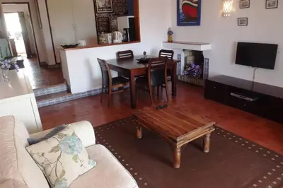 a living room with a table and a dining room at Casa Nill - Apartamento na Praia do Forte de São João em Albufeira in Albufeira