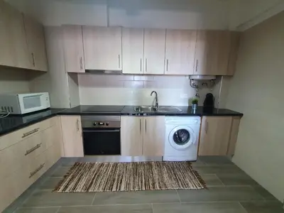 a kitchen with a washing machine and a sink at Apartamento de Quarteira in Quarteira