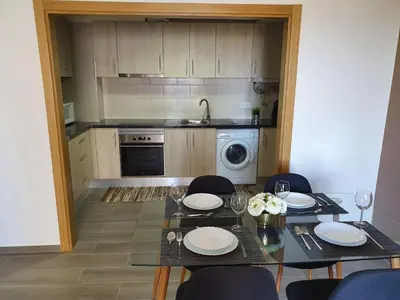 a kitchen with a table and chairs and a kitchen with a sink at Apartamento de Quarteira in Quarteira