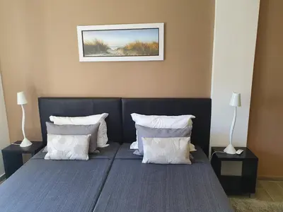 a bedroom with a bed with white pillows at Apartamento de Quarteira in Quarteira