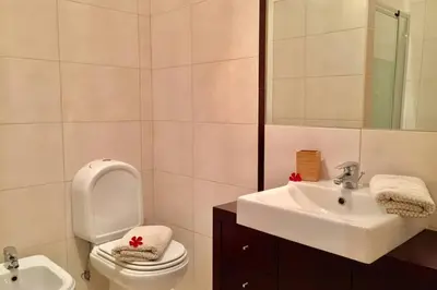 a bathroom with a toilet and a sink at Edificio Sao Joao das areias Strip l OURA in Albufeira