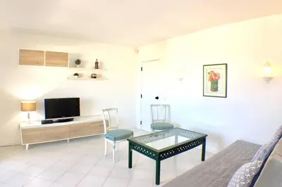 a living room with a television and a table and chairs at Bellavista Avenida Pool and city center in Albufeira