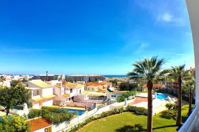 a view of a resort with a pool and palm trees at Bellavista Avenida Pool and city center in Albufeira
