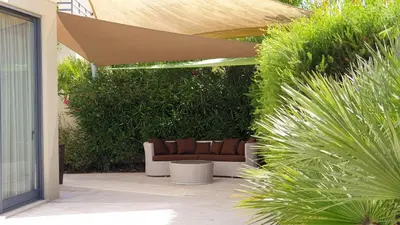 a patio with a couch sitting under an umbrella at Luxury Villa Corcovada Nicole with privat heated pool in Albufeira