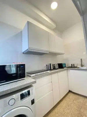 a white kitchen with a microwave and a dishwasher at Faro Downtown Ria Formosa Studios in Faro