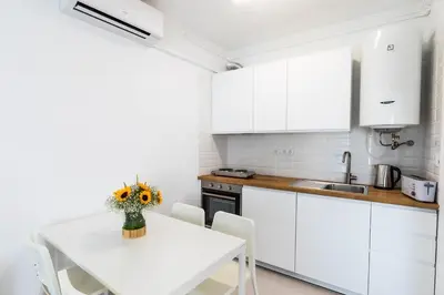 a kitchen with a table with a vase of flowers on it at Faro Downtown Ria Formosa Studios in Faro