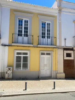 a yellow building with two doors and two windows at Faro Downtown Ria Formosa Studios in Faro