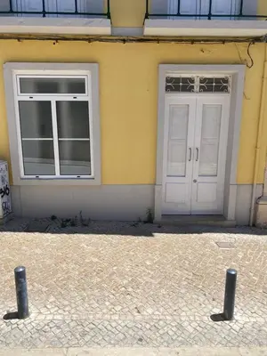 a yellow building with two windows and a door at Faro Downtown Ria Formosa Studios in Faro