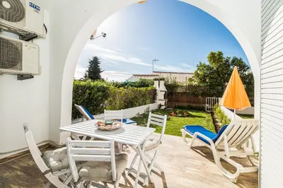 a patio with a table and chairs and an umbrella at Edif. Valemangude in Albufeira