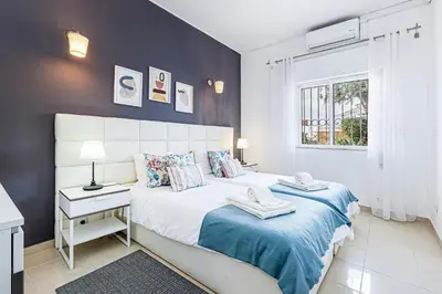 a bedroom with a large bed with a blue blanket at Edif. Valemangude in Albufeira