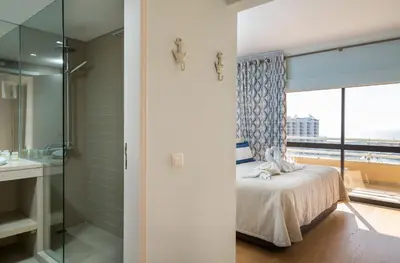 a bedroom with a bed and a glass shower at Marina Mar 'Penthouse' by SAPvillas in Vilamoura