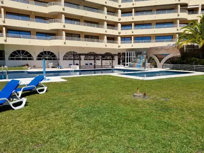 a large building with a lawn in front of a swimming pool at Marina Mar 'Penthouse' by SAPvillas in Vilamoura