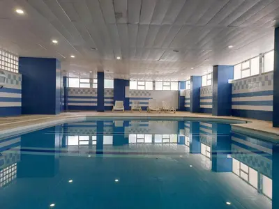 a large swimming pool with blue water in a building at Marina Mar 'Penthouse' by SAPvillas in Vilamoura