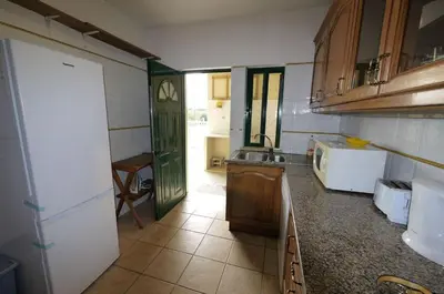 a kitchen with a sink and a refrigerator in it at Villa Vacations House in Albufeira