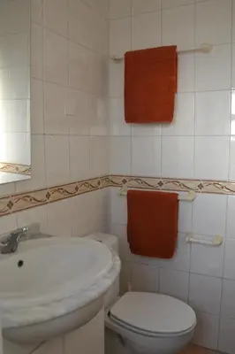 a bathroom with a white toilet and a sink at Villa Vacations House in Albufeira
