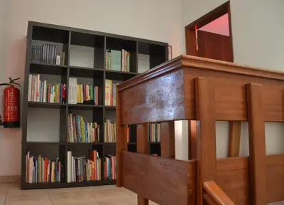 a book shelf filled with books next to a bed at Villa Vacations House in Albufeira