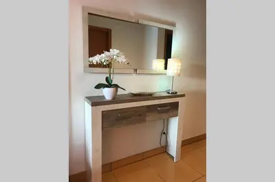 a bathroom with a vanity with a mirror and flowers at Colorful Cozy Apartment view in Albufeira