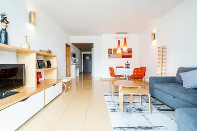 a living room with a blue couch and a table at Colorful Cozy Apartment view in Albufeira