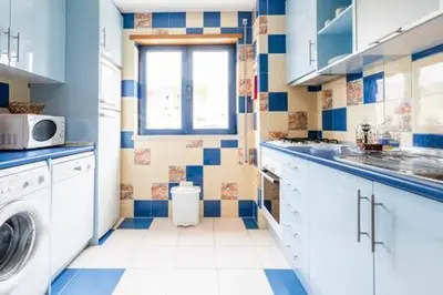 a blue and white kitchen with a washing machine at Colorful Cozy Apartment view in Albufeira