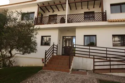 a house with a staircase leading to the front door at O Pinheiro - Apartment Hannah in Olhos de Água