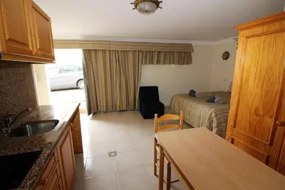 a kitchen and living room with a couch and a table at Waves Studio - Albufeira in Albufeira