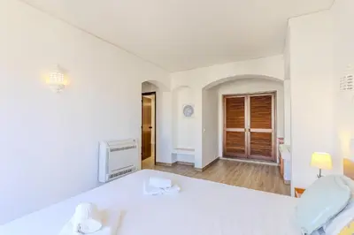a bedroom with two beds and a desk and a mirror at #015 Buganvilia by Home Holidays in Albufeira