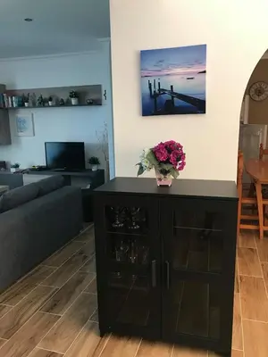 a living room with a black cabinet with flowers on it at Quinta Vita - Vila Pera in Almancil
