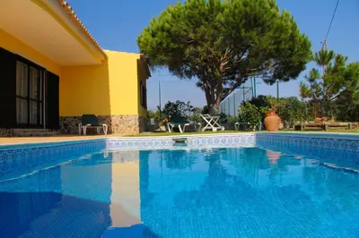 a swimming pool in front of a house at Quinta Vita - Vila Pera in Almancil