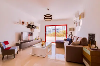 a living room with a couch and a tv at Varandas do Mar - Near the beach - Quarteira in Quarteira