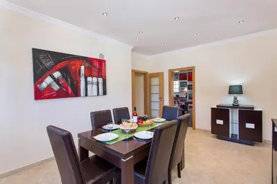 a dining room table with chairs and a painting on the wall at Villa Nincha - Heated Pool - Free wi-fi - Air Con in Albufeira