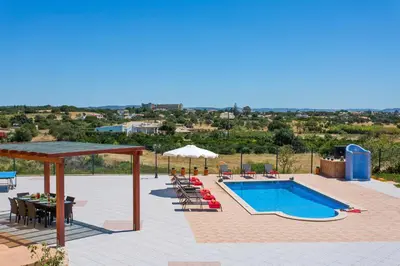 a patio with a pool and a table and chairs at Villa Nincha - Heated Pool - Free wi-fi - Air Con in Albufeira