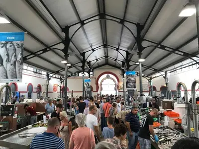 a crowd of people standing in a large market at Bicas Velhas Studio in Loulé