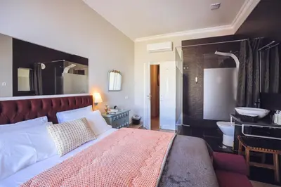 a bedroom with a large bed and a bathroom at Downtown Loulé in Loulé