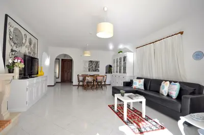 a white house with a yard with green grass at Charming Villa, Private Pool, Walking Distance to Centre, Free AC Wifi in Quarteira