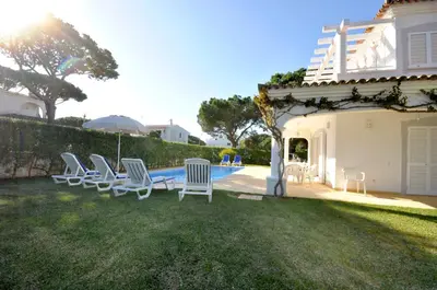 a kitchen and living room with a table and a refrigerator at Charming Villa, Private Pool, Walking Distance to Centre, Free AC Wifi in Quarteira