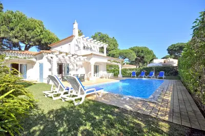 a bedroom with a large bed and a wooden cabinet at Charming Villa, Private Pool, Walking Distance to Centre, Free AC Wifi in Quarteira