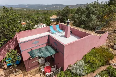 an overhead view of a pink house with two blue chairs at Casa Adega - Quinta Amoreira in Faro