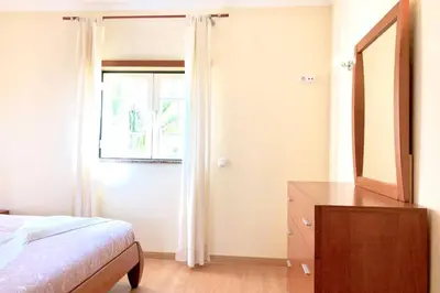 a bedroom with a bed and a dresser and a window at Albufeira edificio Marina Inn Pateo in Albufeira