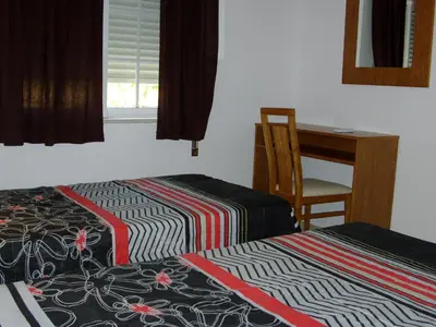a room with two beds and a desk and a table at Albufeira 1 bedroom apartment 5 min from Falesia beach and close to center J in Albufeira