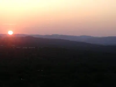 a sunset with the sun setting over the mountains at Casa Amoreira - Quinta Amoreira in Faro