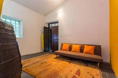 a room with a couch with two orange pillows on it at Casa Amoreira - Quinta Amoreira in Faro