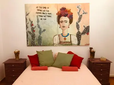 a bedroom with a bed with a painting on the wall at The Portuguese Element in Faro