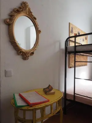 a mirror on a wall next to a table with books at The Portuguese Element in Faro